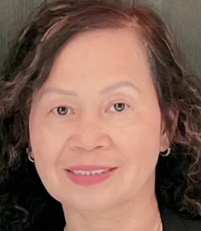Maria J. Clardy smiling, with long dark wavy hair.