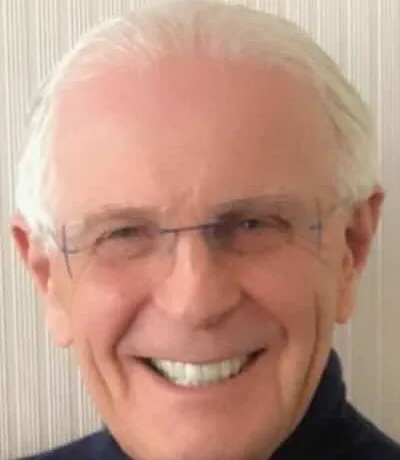 Dr. Patrick Wherry smiling, wearing glasses and a navy sweater.